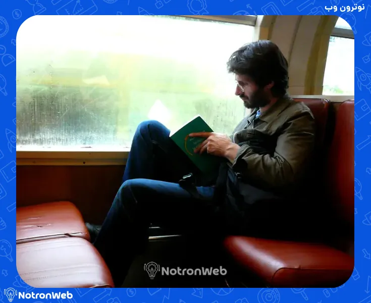 یک مرد در حال خواندن کتاب نشسته در قطار